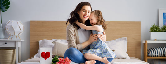 mother and daughter sitting in bed on Mother's Day